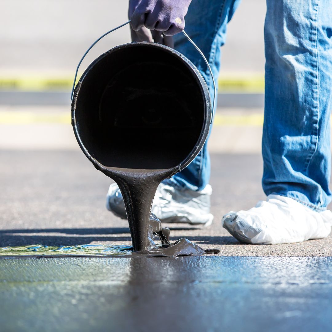 Pouring Black Tar Seal Coating Onto Driveway