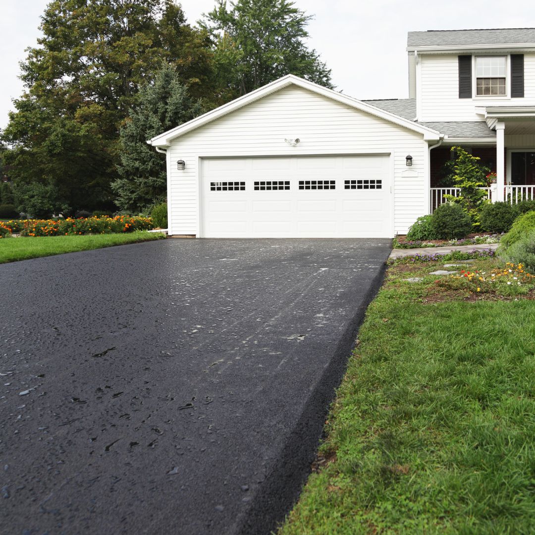 Rain Puddles on New Asphalt Driveway at Residential Home